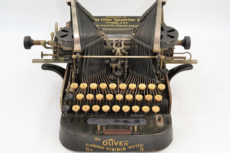 Compact, metal, a very high carriage with long key arms that swing down from the sides, unlike the standard that hammers front onto the ink ribbon. Oliver's name in raised letters on the side painted text along with on the back panel and on the base. Used by the Medical Examiners Office for the City of Philadelphia into the early 20th century.