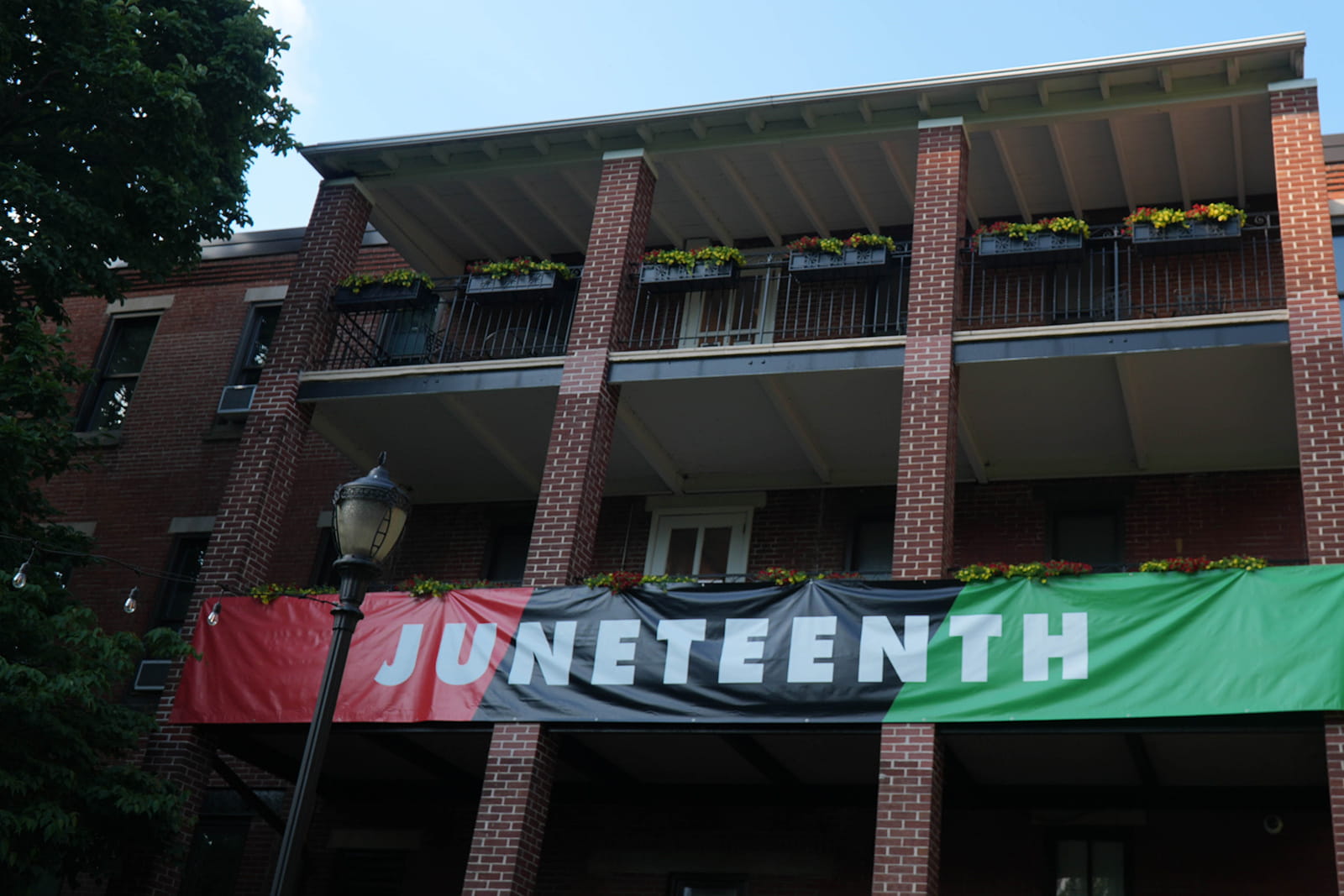 A Juneteenth banner hanging on the exterior of the Rush Building.