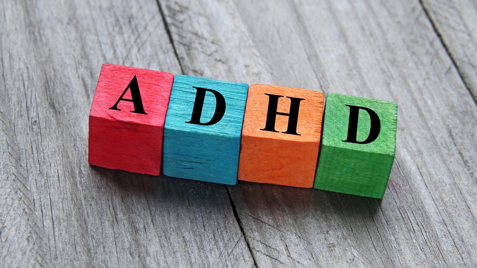 four wooden blocks with the letters ADHD