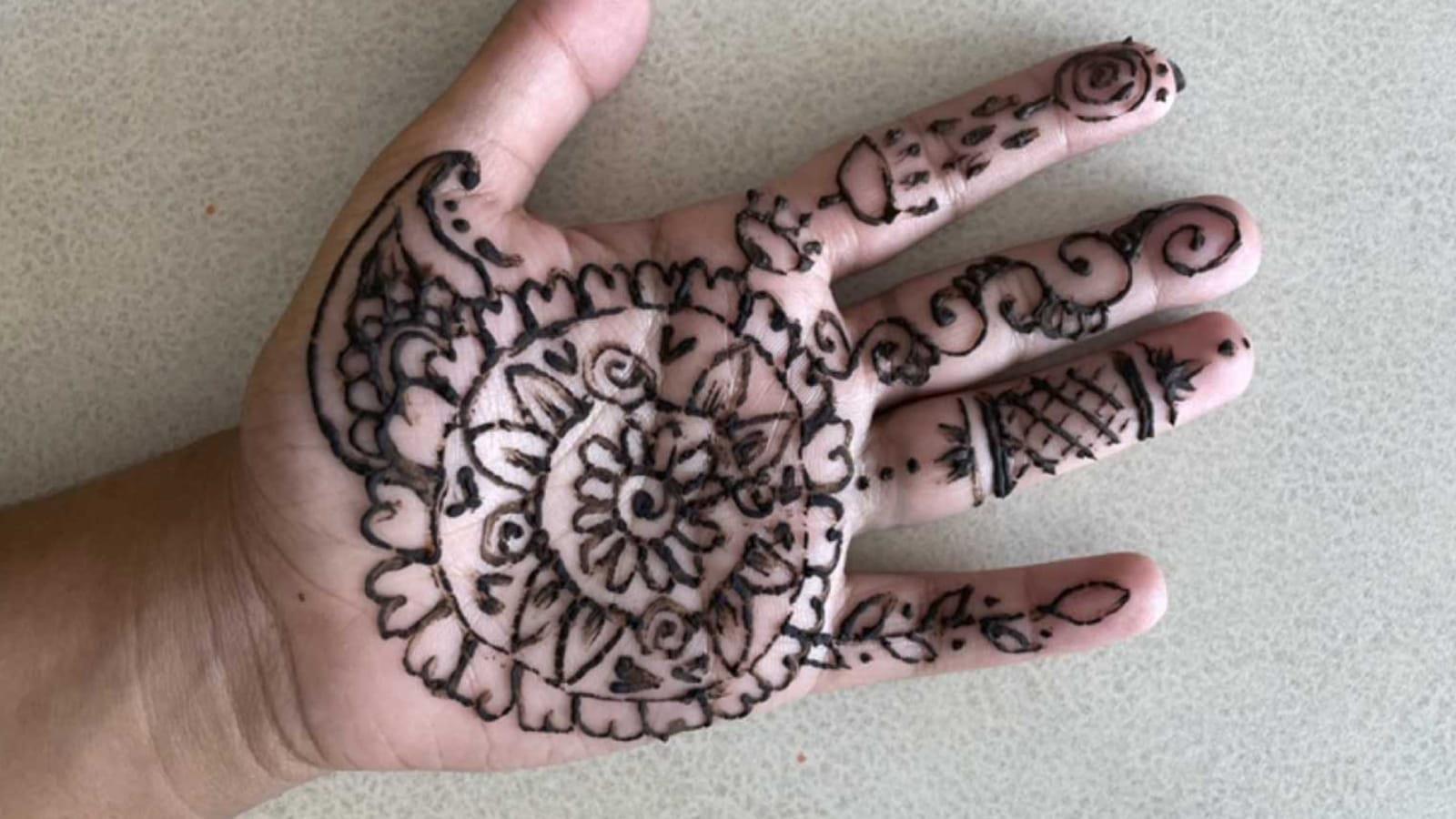An intricate henna design on the palm of a hand